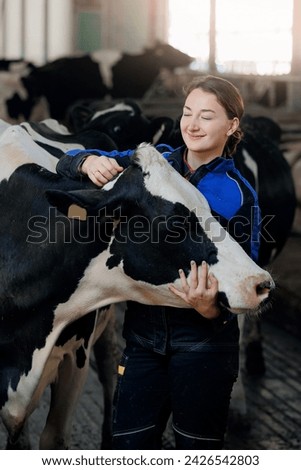 Happy young woman farm worker hugging cow as sign of concern for animal health care. Concept agriculture cattle livestock farming industry.