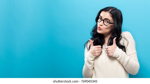 Happy Young Woman Giving Thumbs Up On A Solid Background