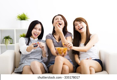 Happy Young Woman Group  Eating Snacks And Watching The Tv