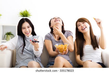 Happy Young Woman Group  Eating Snacks And Watching The Tv