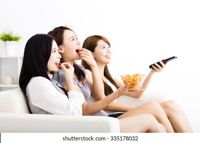 Happy Young Woman Group  Eating Snacks And Watching The Tv