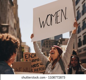 Happy Young Woman Hand Written Protest Sign At Women's March. Group Of Females Demonstrating Outdoors.