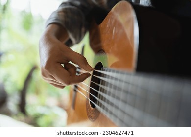 Happy young Woman hands playing acoustic guitar musician  alone compose instrumental song lesson on playing the guitar. - Powered by Shutterstock