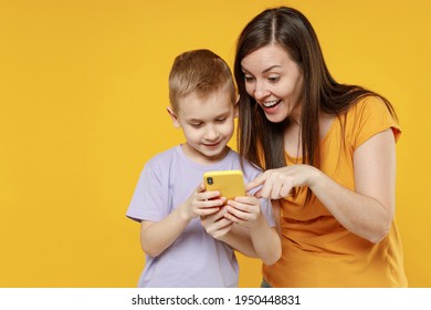 Happy young woman have fun with child baby boy 5-6-7 years old in violet t-shirt hold use mobile cell phone. Mommy little kid son together isolated on yellow background studio Mother's Day love family - Powered by Shutterstock