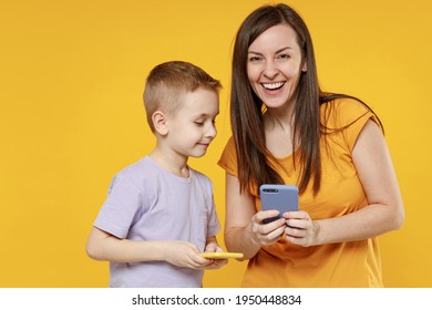 Happy young woman have fun with child baby boy 5-6-7 years old in violet t-shirt hold use mobile cell phone. Mommy little kid son together isolated on yellow background studio Mother's Day love family - Powered by Shutterstock