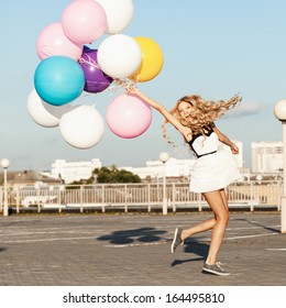 Happy Young Woman Having Fun With Colorful Latex Balloons.  Gorgeous Thick Wavy Hair. Outdoors, Lifestyle