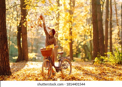 Happy Young Woman Having Fun And Playing With Autumn Yellow Leaves In Autumn Park.  Relaxation, Enjoying, Solitude With Nature.