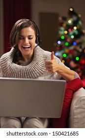 Happy Young Woman Having Video Chat With Family In Front Of Christmas Tree