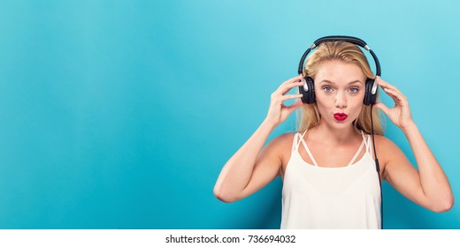 Happy Young Woman With Headphones On A Solid Background