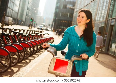 Happy Young Woman With A Hire Bike In London