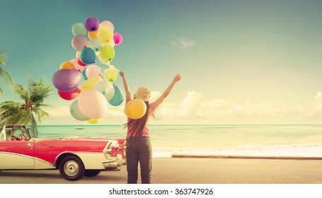 Happy young woman holding colorful balloons with floating, concept of journey honeymoon in summer on tropical beach blue sky - vintage color tone