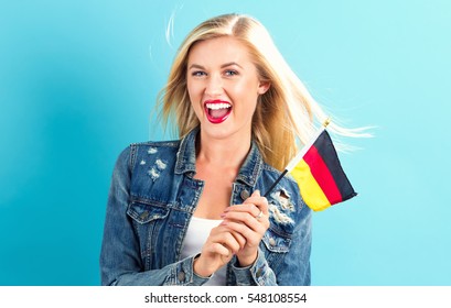 Happy Young Woman Holding German Flag On A Blue Background