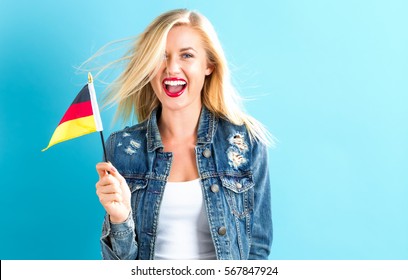 Happy Young Woman Holding German Flag On A Blue Background