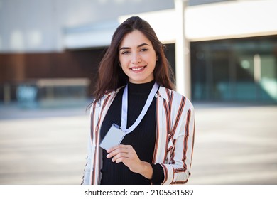 Happy Young Woman Holding An ID Card On Urban Background