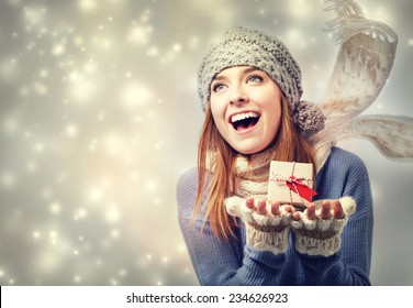 Happy Young Woman Holding A Small Present Box In Snowy Night