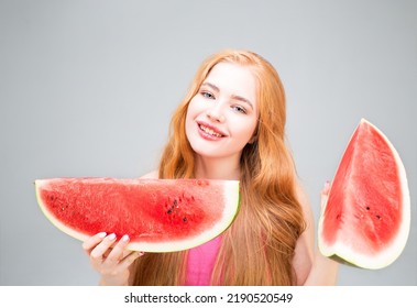 Happy young woman holding watermelon halves isolated on gray background. Healthy eating concept. Diet.