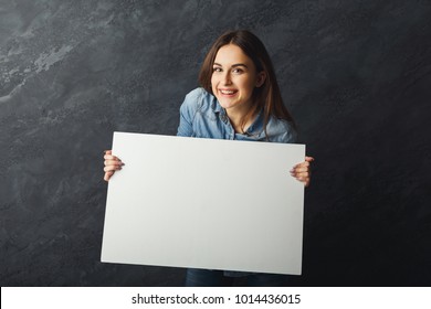 Happy Young Woman Holding White Blank Banner. Excited Girl Showing Paper Sheet For Sales Advertisement, Copy Space. Commercial Ad Mockup