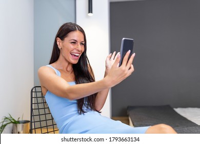 Happy Young Woman At Home Making Facetime Video Calling With Smartphone At Home, Using Zoom Meeting Online App, Social Distancing, Work From Home, Work Remotely Concept