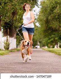 Happy Young Woman Jogging With Her Beagle Dog