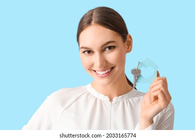 Happy Young Woman With Key From House On Color Background