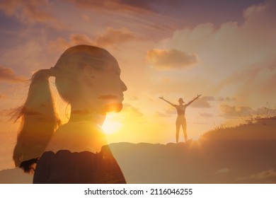 Happy young woman lifting her arms up standing onto mountain feeling inspired and positive. Finding freedom and hope concept. 