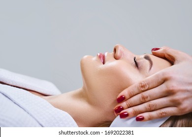 Happy Young Woman Is Lying On Couch While Face Expert Is Working With Her Skin