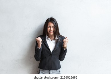 Happy Young Woman Making A Yay Gesture. Exited Freelancer Business Woman Or Student Yes Gesture With Her Hands And Smiling While Standing For Successful Job Interview Or Pas Exam.