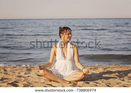 Happy young woman meditating by the sea shore