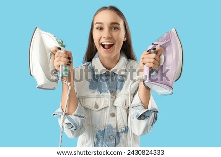 Happy young woman with modern irons on blue background