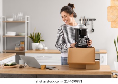 Happy young woman with new coffee maker at home. Online shopping - Shutterstock ID 2144699971