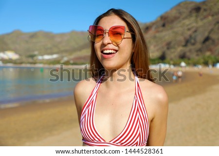 Happy young woman on the beach. Outdoor fashion portrait of lady enjoying her vacation on hot tropical island.