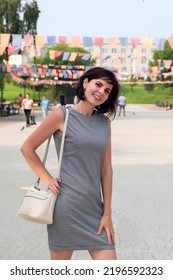 Happy Young Woman On A City Holiday. Standing In A Busy City Square.