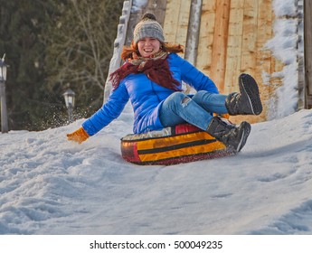 Happy Young Woman on a fast Sleigh Ride down the icy slope - Shutterstock ID 500049235