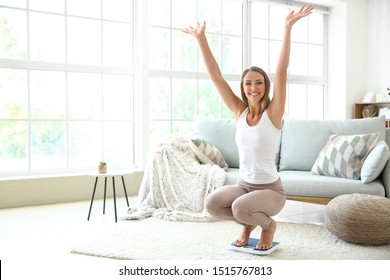 Happy Young Woman On Scales At Home. Weight Loss Concept