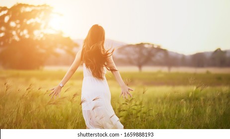 Happy Young Woman On The Sunset Or Sunrise In Summer Nature