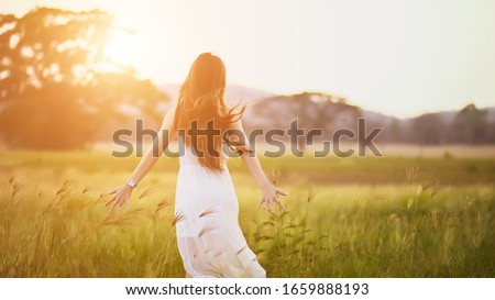 Happy young woman on the sunset or sunrise in summer nature