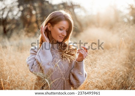 Happy young woman on a walk in an autumn park on a warm sunny day. Beautiful portrait of a Caucasian girl in an autumn coat walks on a warm sunny day in the autumn park. 
