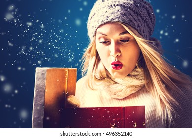 Happy young woman opening a Christmas present box - Powered by Shutterstock