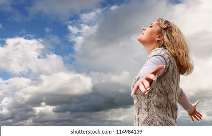Happy young woman with outstretched arms on the blue cloudy sky view - Shutterstock ID 114984139