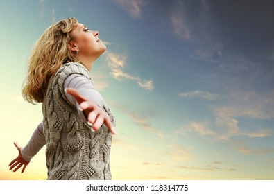 Happy young woman with outstretched arms on the autumn sky view - Shutterstock ID 118314775