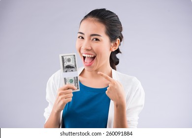 Happy Young Woman Pointing At The Money In Her Hand