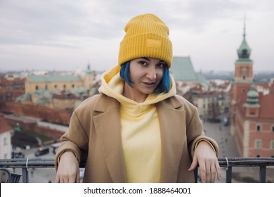 Happy young woman portrait with colored blue hair in coat in front of old town and Christmas tree - Shutterstock ID 1888464001