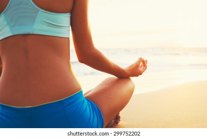 Fröhliche junge Frau, die bei Sonnenuntergang Yoga am Strand praktiziert. Gesundes aktives Lifestyle-Konzept.