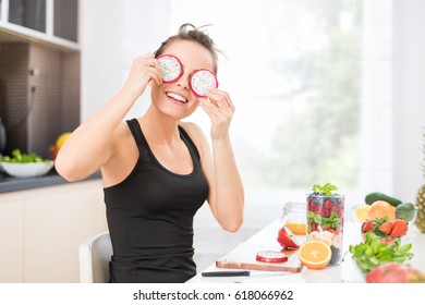 Happy Young Woman Puts Slices Of Dragon Fruit As Glasses. Healthy Eating - Concept.