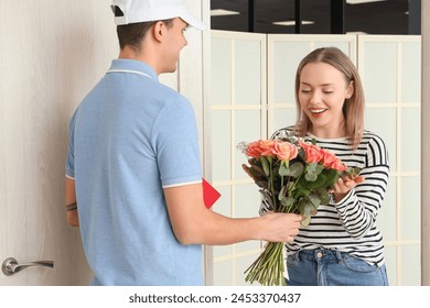 Happy young woman receiving bouquet of flowers from courier at door - Powered by Shutterstock