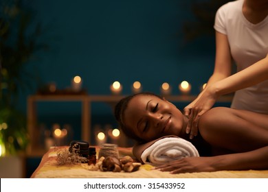 Happy young woman receiving relaxing back massage