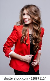 Happy Young Woman In Red Jacket. Studio Shoot