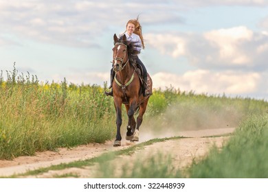 Happy young woman riding bay horse. 