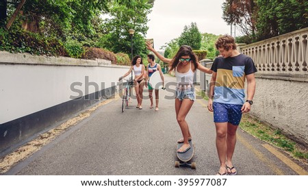 Similar – Young man riding on skate and holding surfboard