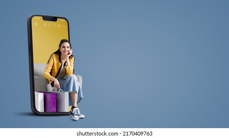 Happy young woman with shopping bags in a smartphone, online shopping and sales concept, blank copy space - Shutterstock ID 2170409763